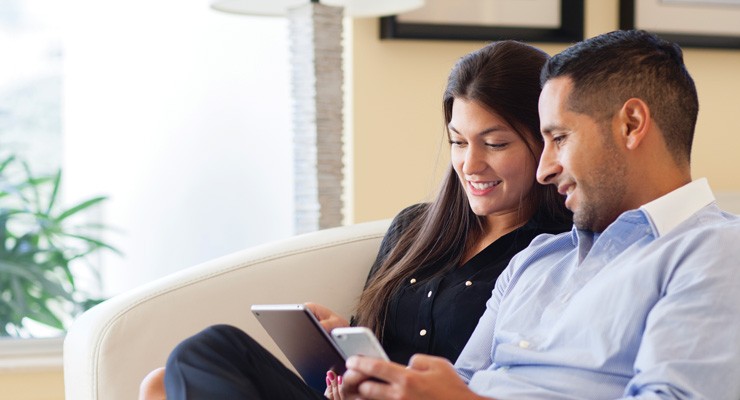 man and woman looking at cellphone and tablet